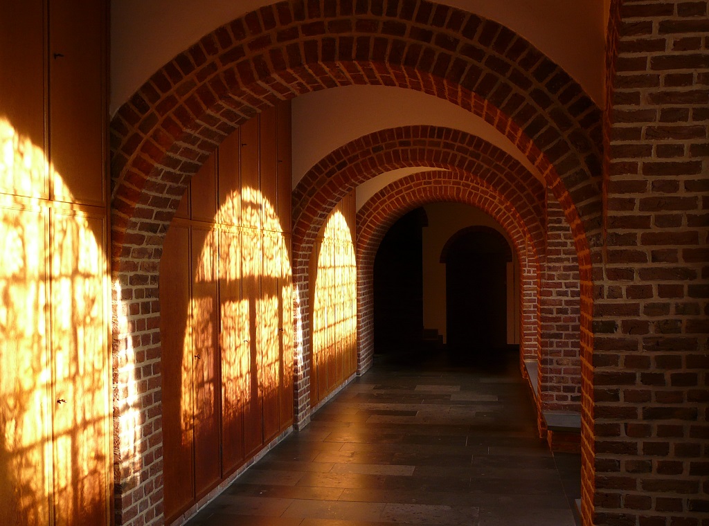 Eine Kerze im Pilgerkloster Werl. Im Hintergrund leuchten verschiedene Farben verschwommen. Eine Kerze im Pilgerkloster Werl. Im Hintergrund leuchten verschiedene Farben verschwommen.
